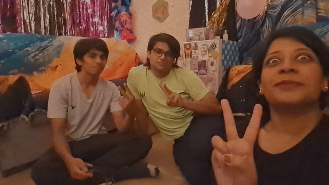 The three of us on the floor of the decorated room, peace signs all round.