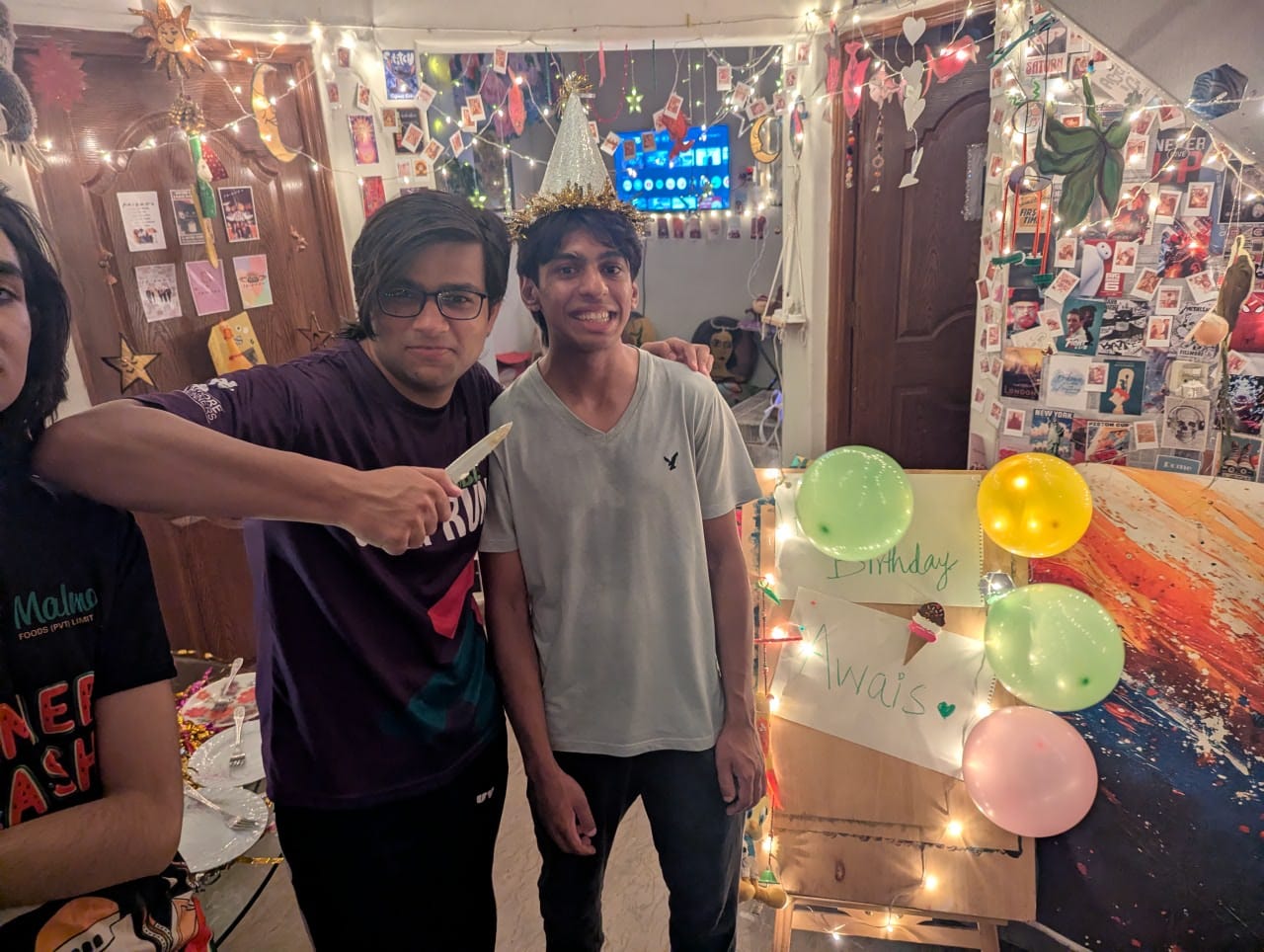The birthday boy in a golden crown beside the cake, the hand-drawn sign on its easel behind.